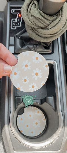 a person is holding a piece of paper over a stove top burner with a flower design on it