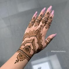 a woman's hand with henna tattoos on it