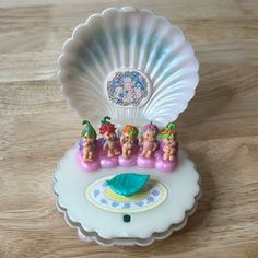 there is a small plastic toy in the shape of a shell with little figurines on it