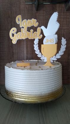 a cake decorated with a dove and laurel decoration on top is sitting on a table