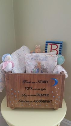 a wooden box filled with baby's toys sitting on top of a white table