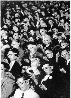 a crowd of people wearing masks and holding cell phones in front of their faces, all looking up at the same person