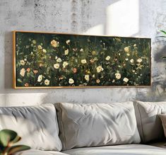 a painting hanging on the wall above a couch in a living room with white pillows