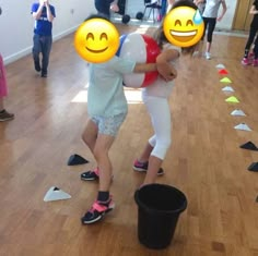 two children are playing with each other on the floor in front of some plastic cups