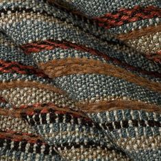 closeup of the texture of an upholstered, multicolored blanket with red and blue stripes