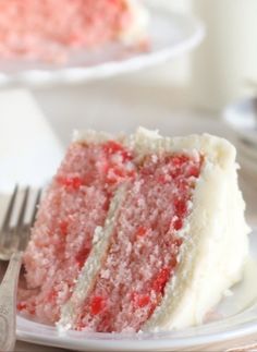 a slice of strawberry cake on a plate with a fork