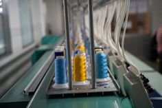 several spools of thread sitting on top of a machine that is spinning them