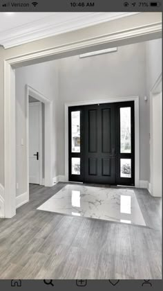 an empty room with two black doors and white trim on the walls is seen in this image