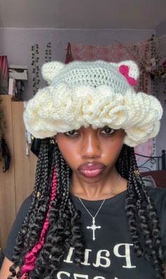 a woman wearing a crochet hat with braids