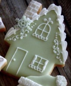 some cookies with icing and decorations on top of a wooden table next to each other