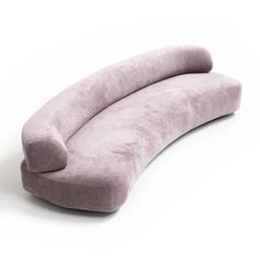 the curved sofa is made from light purple fabric and has a long, rounded shape