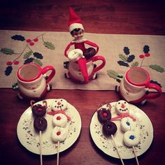 a table topped with plates and cupcakes covered in frosted doughnuts