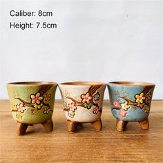 three vases sitting on top of a wooden table