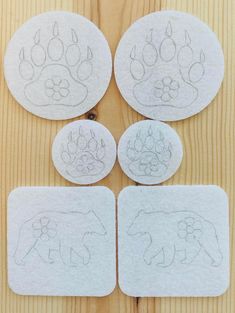 four coasters that have been cut out to look like bears and paw prints on them