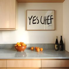 a bowl of oranges sitting on top of a kitchen counter