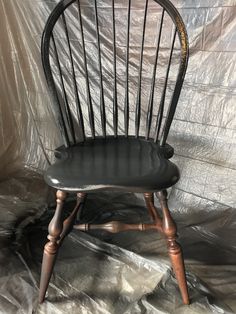 a black chair sitting on top of a white sheet