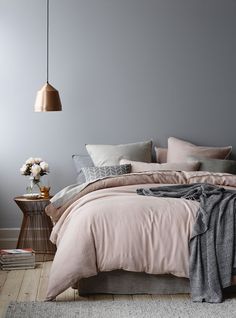 a bedroom with grey walls and pink bedding