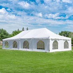 a large white tent set up in the middle of a field with windows on each side