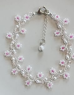 Handmade flower bracelet using quality Japanese and/or Czech seed beads in translucent white and fuschia. In-between are faux pearls and square glass beads. The ends are finished with a silvertone heart shaped lobster claw clasp and a stainless steel extension chain with faux pearl charm. This bracelet measures approximately 7.5" with an additional 1" extender chain. Protect from excess moisture such as water, sprays and lotions. White Beaded Chain Pearl Bracelet Gift, Handmade White Pearl Bracelet With Flower Shape, Handmade White Pearl Flower Bracelet, Pink Pearl Jewelry With Tiny Beads, White Pearl Bracelet With Beaded Chain, Handmade White Flower Pearl Bracelet, White Beaded Pearl Bracelet With Flower Shape, White Beaded Pearl Bracelet With Flower Design, White Beaded Flower Pearl Bracelet