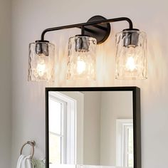 a bathroom vanity with two lights and a mirror