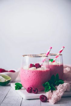 two glasses filled with raspberry smoothie and topped with minty garnish