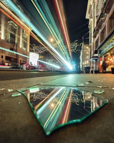 a street scene with focus on the ground and buildings in the background at night time