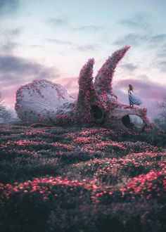 a woman standing on top of a giant piece of art in the middle of a field