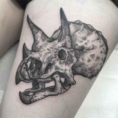 a rhino skull tattoo on the thigh