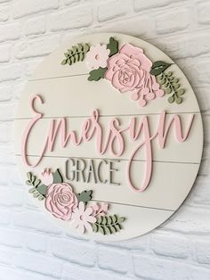 a white sign with pink flowers and green leaves on it that says, emerson grace