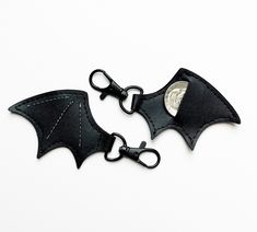 two black bat shaped key chains on white background