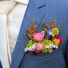 a man wearing a blue suit with flowers on it's lapel flower bouquet