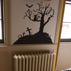 a wall decal with a tree and bats on it in a room next to a radiator