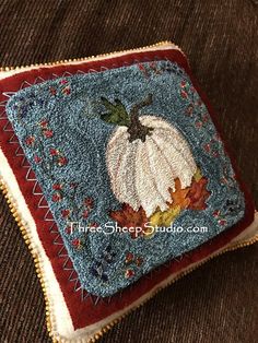 a close up of a pillow with a pumpkin on it