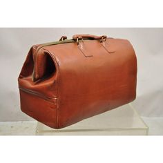 a brown leather bag sitting on top of a glass stand