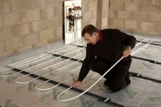 a man kneeling down on the floor with wires attached to it