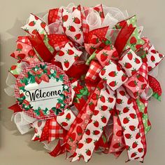 a red and white wreath with strawberries on it that reads welcome to the strawberry patch