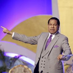 a man in a suit and tie standing at a podium with his arms out to the side