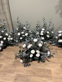 three white flowers are on the floor next to each other