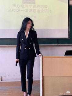 a woman standing in front of a projector screen with her hand on the board