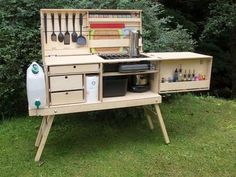 an outdoor kitchen made out of wood and utensils