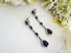 Same Style Earrings-Shorter Length: https://www.etsy.com/listing/1302867248 Similar Designs with Clear and Sapphire Cubic Zirconia: https://www.etsy.com/listing/1337182650 https://www.etsy.com/listing/1414245091 Matching Bracelet: https://www.etsy.com/listing/1353304140 https://www.etsy.com/listing/1456206829 Matching Hair Pin: https://www.etsy.com/listing/880678156 Item #BRER4076 These Handmade, Original Design crystal earrings are comprised of Sapphire Cubic Zirconia Teardrop framed with round CZ crystals, Cubic Zirconia Teardrop Round/Diamond Connectors and Gorgeous Sapphire Cubic Zirconia Inverted Teardrop Ear Stud Posts also framed with round CZ crystals. These earrings just gleam glam. The earrings measure .50" in width and 2.25" in length from top of ear post to tip of earring. Free Blue Drop Bridal Earrings, Blue Teardrop Chandelier Earrings For Anniversary, Blue Drop Bridal Earrings For Party, Blue Dangle Bridal Earrings For Formal Occasions, Formal Blue Dangle Bridal Earrings, Blue Drop Bridal Earrings For Wedding, Blue Teardrop Wedding Earrings, Blue Teardrop Earrings For Anniversary, Blue Dangle Chandelier Earrings For Anniversary