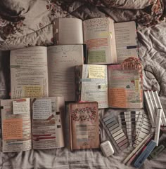 an open book sitting on top of a bed covered in lots of writing and papers