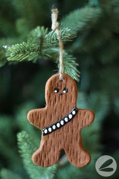 a ginger ornament hanging from a christmas tree with eyes and teeth on it