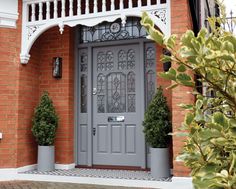 a grey door with two planters on either side