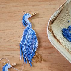 a blue beaded bird ornament sitting next to a bowl on a table