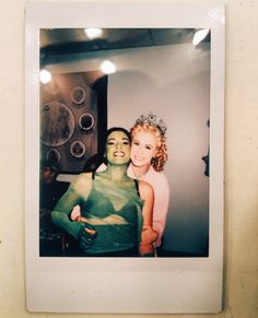 an old photo of two women with green paint on their faces and arms, posing for the camera