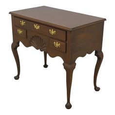 an old wooden desk with drawers on one side and gold decorations on the other end