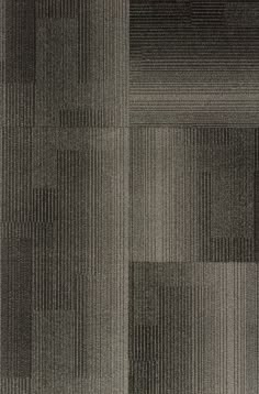 an area rug with squares and lines in grey, black and white colors on the floor