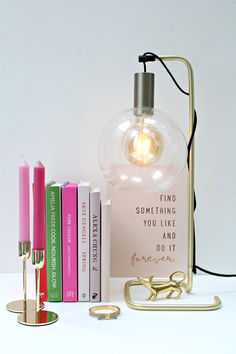 a lamp that is next to some books and a light bulb on top of it