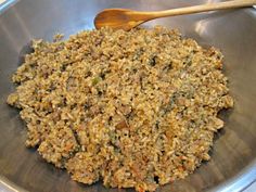 a metal bowl filled with food and a wooden spoon